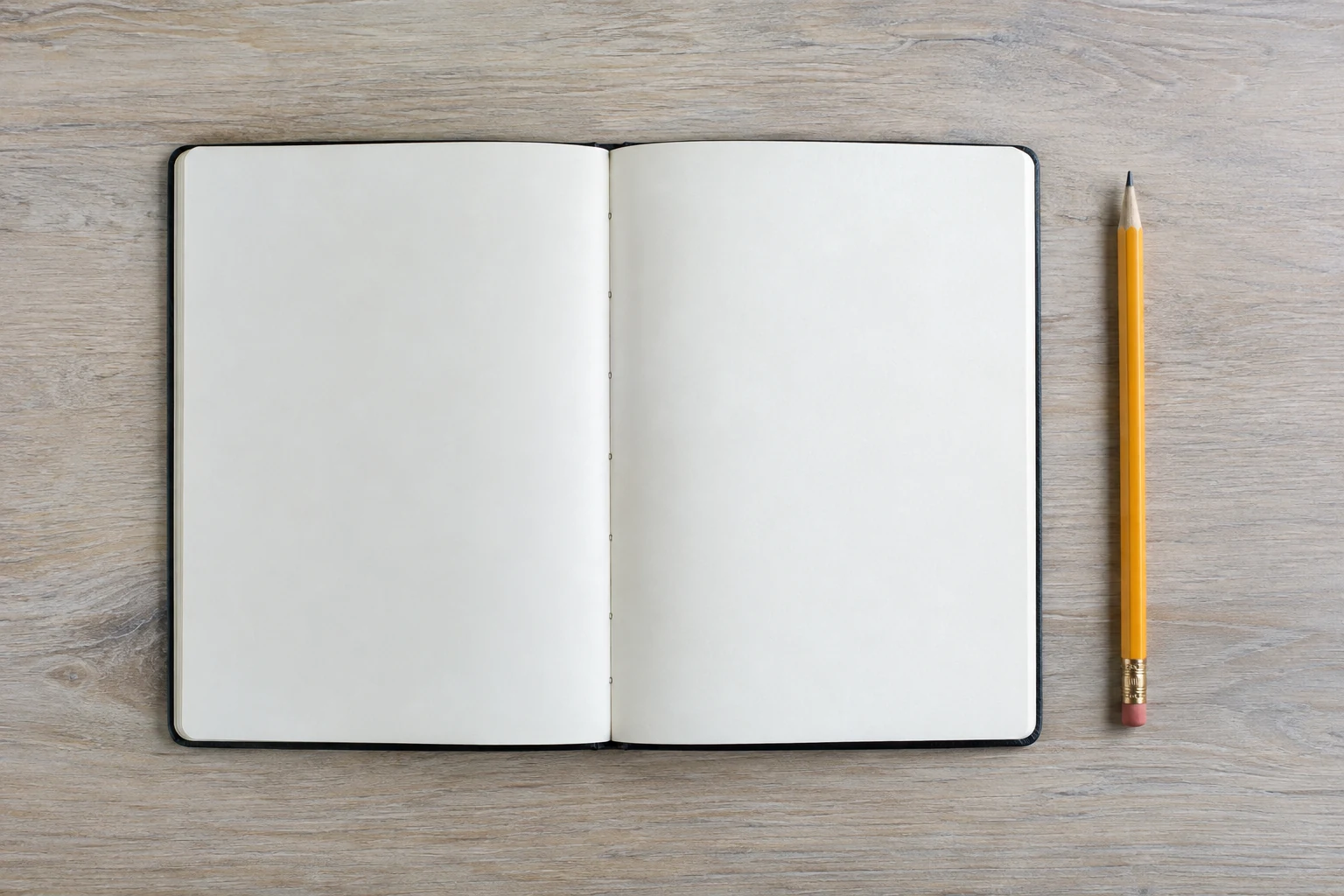 Open blank notebook with a pencil beside it.