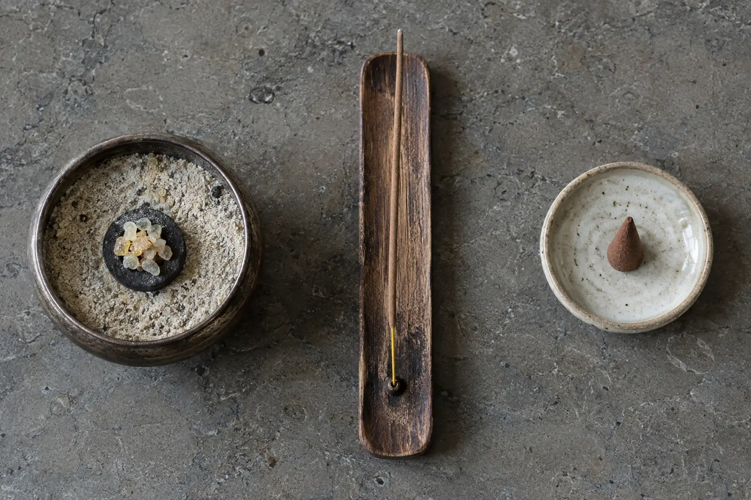 Unlit loose resin, incense stick, and incense cone arranged with three different heatproof holders.