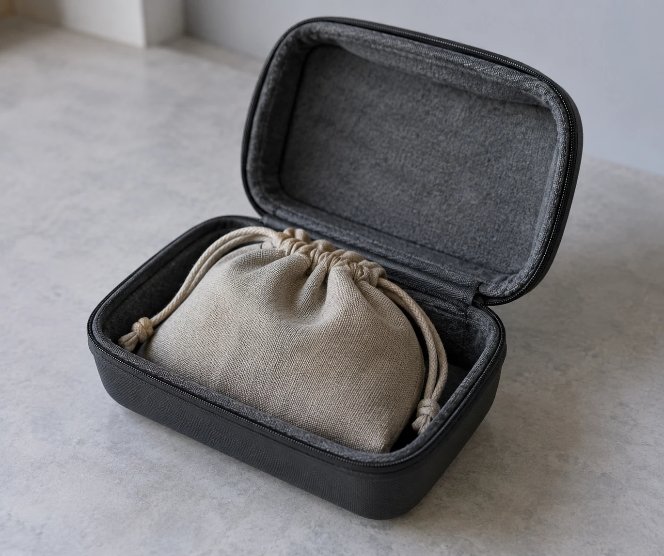 A closed cloth pouch resting inside an open rigid carrying case.