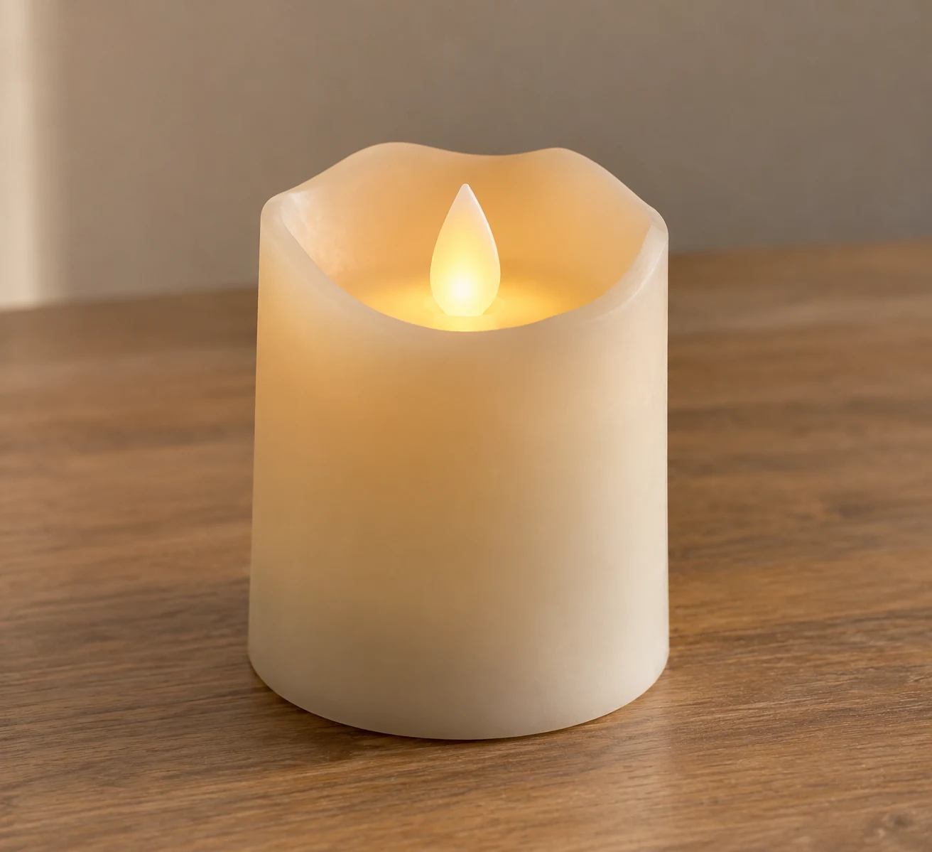 A flameless battery candle standing on a bare tabletop.