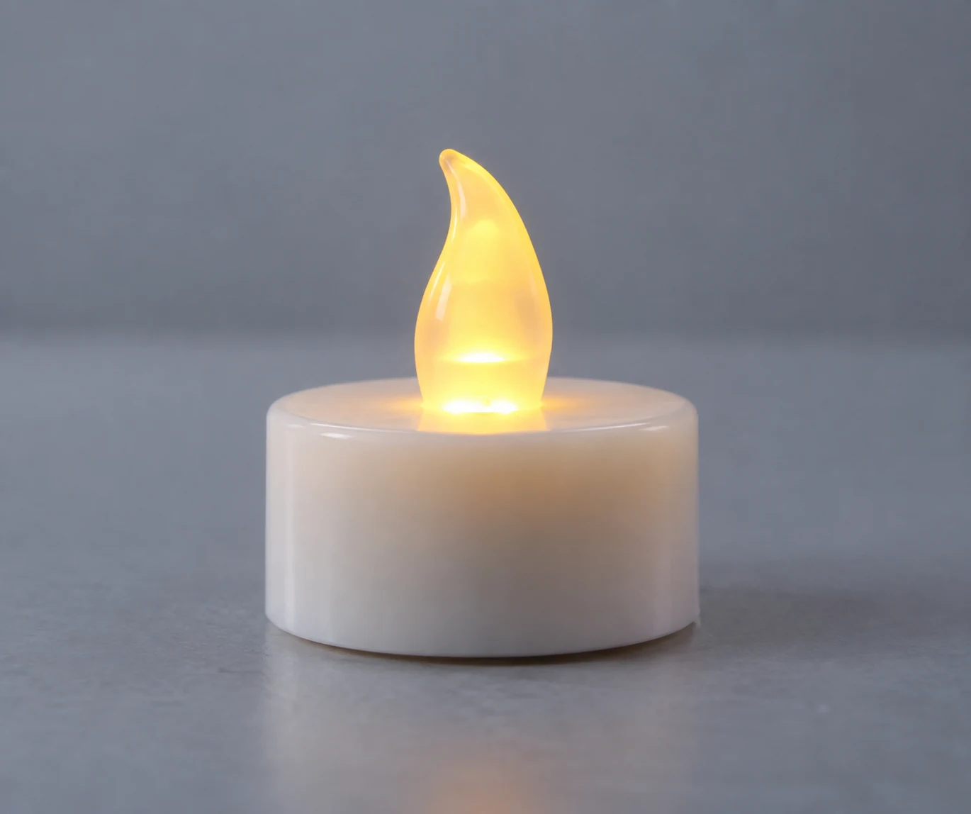 A battery-operated tea light glows through its plastic faux flame.