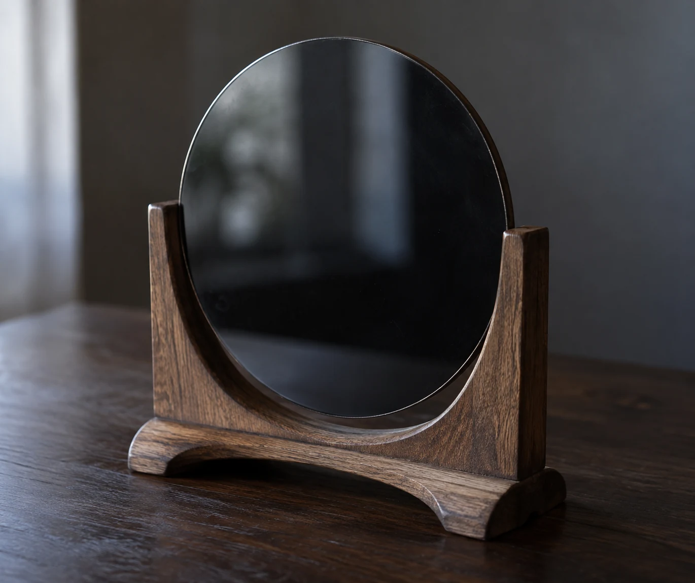Dark scrying mirror resting in a wooden stand.