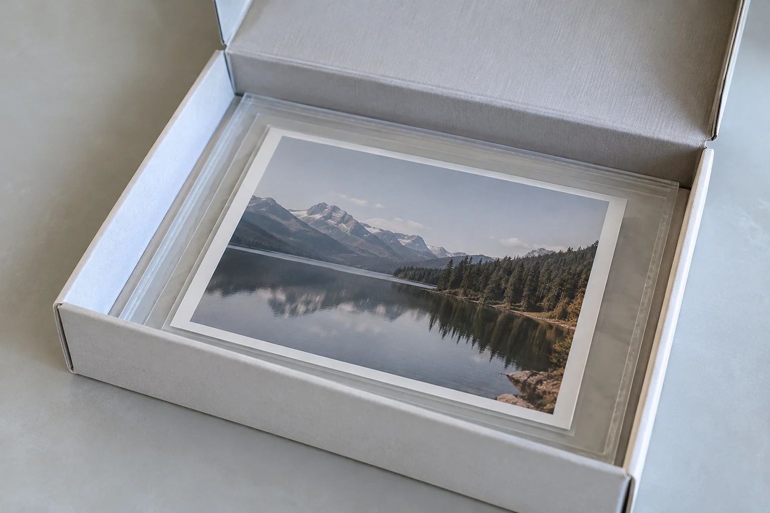 A photograph in a clear enclosure resting flat inside an open storage box.