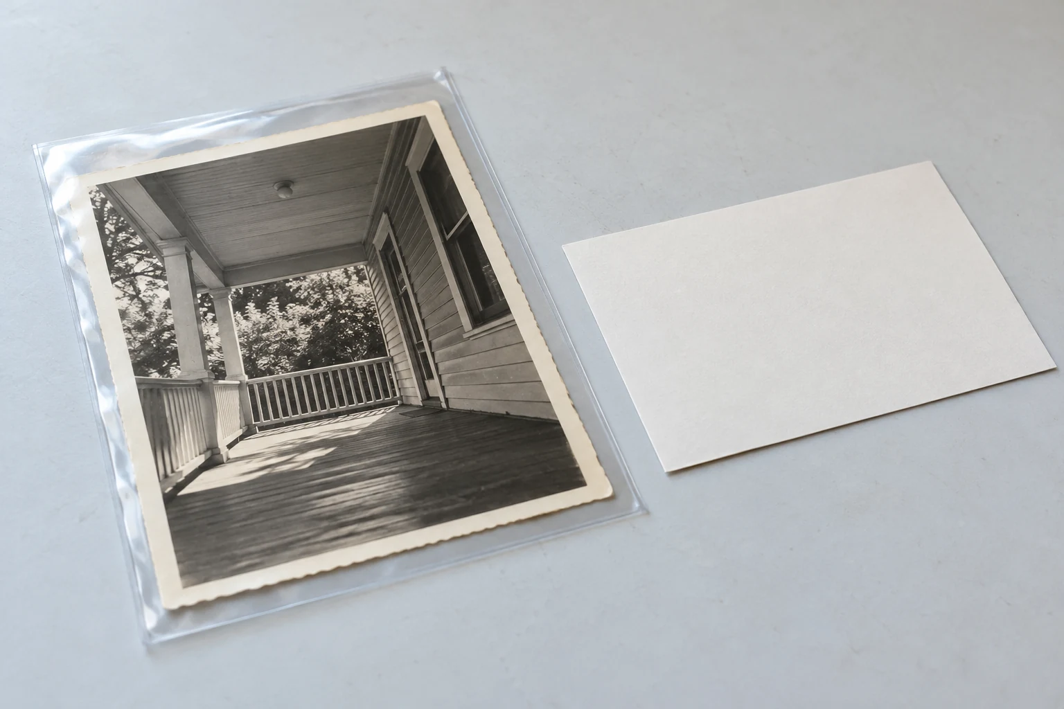 Old porch photograph protected in a clear sleeve, with a separate note card beside it.